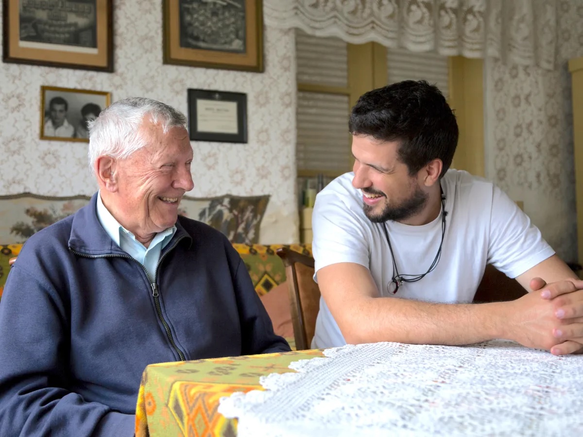 Adult daughter embracing elderly mother in a warm home — love and quiet worry